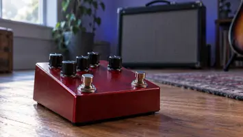 Illustrasjon av en rød gitarpedal med to fotbrytere foran en forsterker.