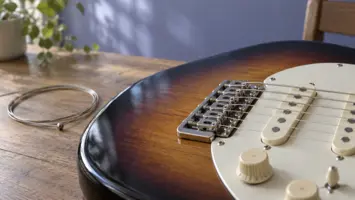 Illustrasjon av strenger over stolen og mikrofonene på en elgitar.